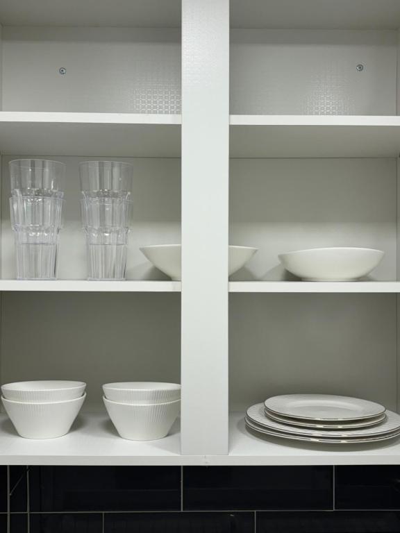 une armoire blanche avec des assiettes, des bols et des verres dans l'établissement Clean 2 SuperSingle Beds House, à Séoul