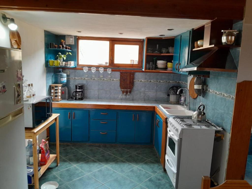 a kitchen with blue cabinets and a stove top oven at Raíces del Bolsón in El Bolsón