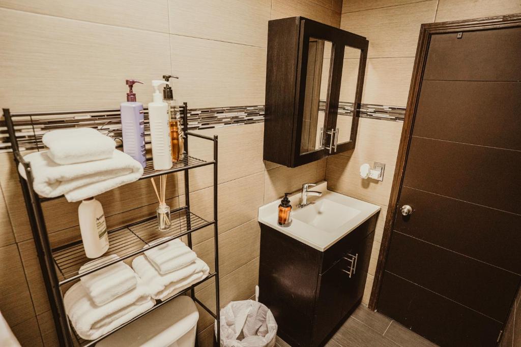 a bathroom with a sink and a toilet with towels at Casa Panda near Airport / Shopping Plaza and International Border in Tijuana