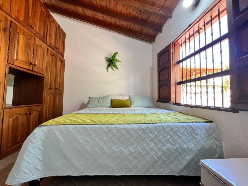 a bedroom with a large bed with a window at EL FAUNO in Jericó