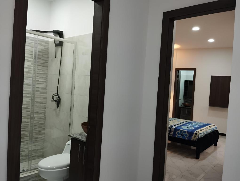 a bathroom with a toilet and a sink and a mirror at Casa cerca del Terminal de SANTO DOMINGO in Santo Domingo de los Colorados