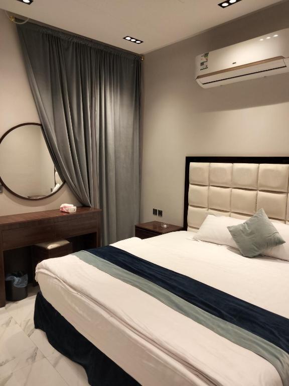 1 dormitorio con 1 cama grande y espejo en مساكن الريان, en Riad