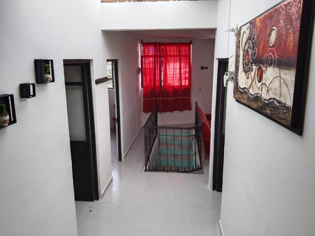 un couloir avec une fenêtre rouge et un tableau sur le mur dans l'établissement Las mariposas 5, à San Cristóbal de Las Casas