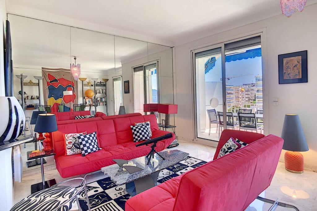- un salon avec un canapé et des fauteuils rouges dans l'établissement Superb 2 bedroom apartment with sea view on the Croisette, à Cannes