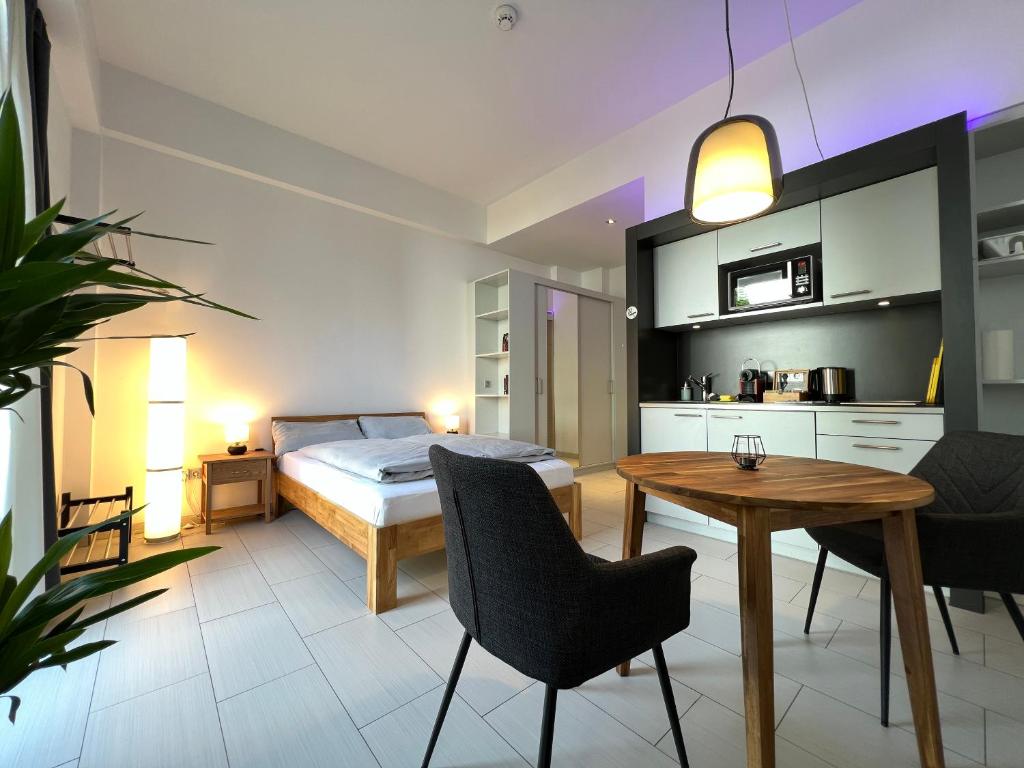 1 dormitorio con 1 cama, mesa y sillas en The East Apartment by Rabe - Netflix & Coffee & Parkplatz en Karlsruhe