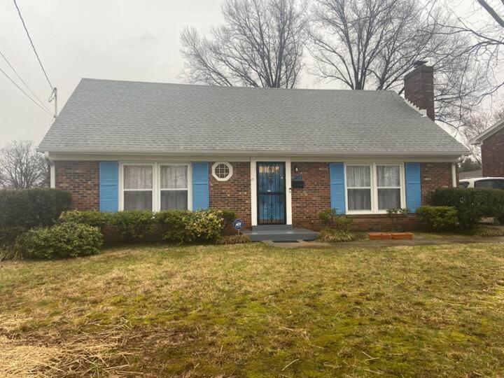 uma casa de tijolos com uma porta azul num quintal em A quiet Place em Louisville