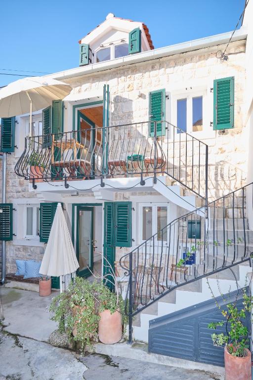a building with a staircase and green shutters at Heritage House in Historic Center of Split in Split