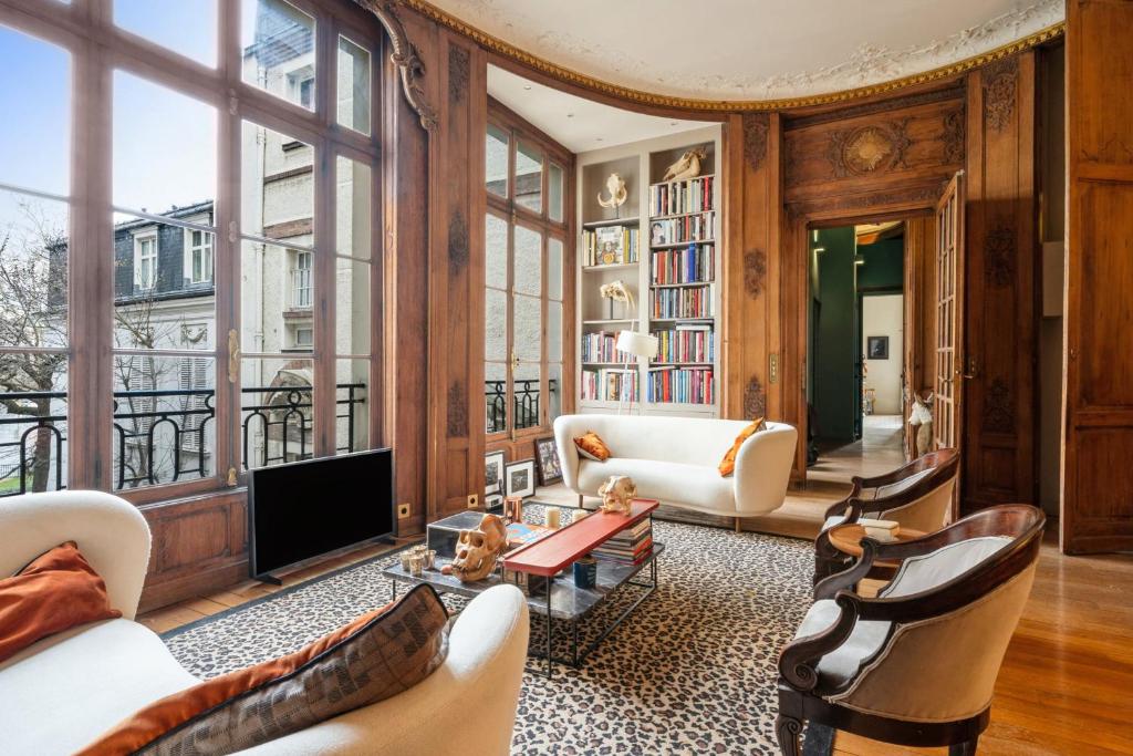 a living room with white furniture and large windows at Elegant historic apartment in Paris - Welkeys in Paris