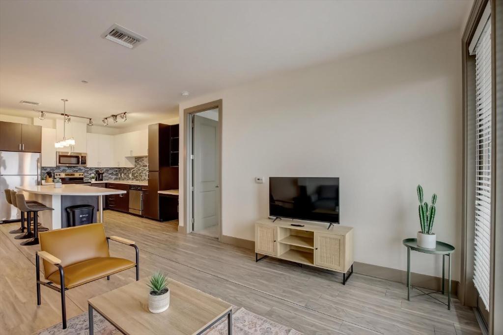 a living room with a television and a kitchen at Modern 2BR CozySuites on Town Lake waterfront 12 in Tempe