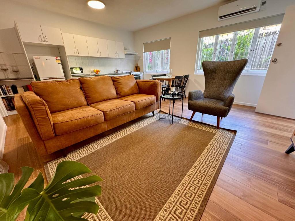 a living room with a brown couch and a chair at 3 Bed Budget Accom Hidden Gem Parking Near Gabba in Brisbane