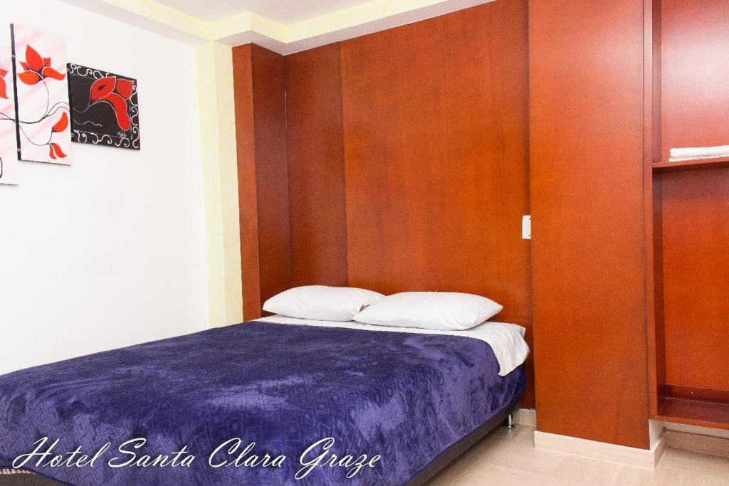 - une chambre avec un lit et un mur en bois dans l'établissement Hotel Santa Clara Graze, à Pasto