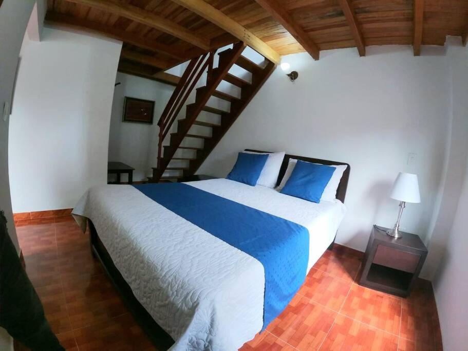 een slaapkamer met een groot bed met blauwe kussens bij SA Cabaña cómoda y acogedora in San Agustín