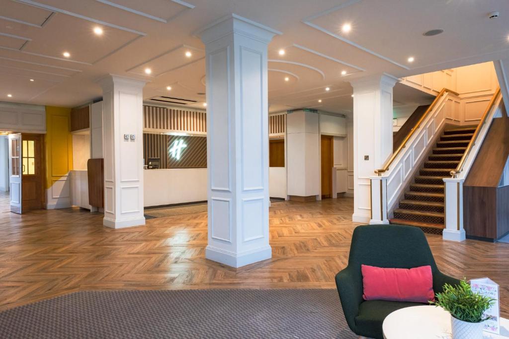 - un hall avec des colonnes blanches, une chaise et des escaliers dans l'établissement Holiday Inn Doncaster A1- M Jct 36, an IHG Hotel, à Doncaster