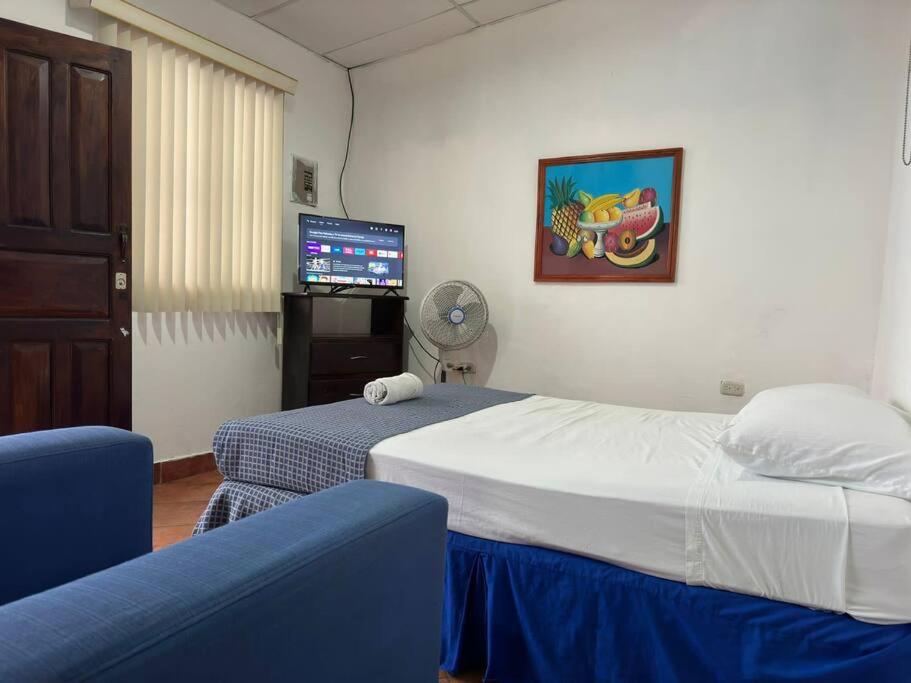 Una habitación de hotel con dos camas y un televisor. en Apartamento Nilxon / Habitación, en Granada