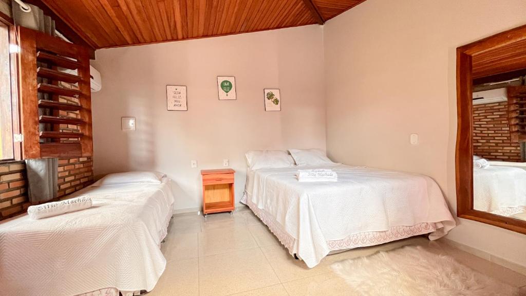 a bedroom with two beds and a tv in it at Pousada Sítio Machado in Viçosa do Ceará