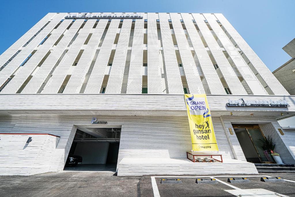 a tall white building with a yellow sign on it at Hey Gunsan Hotel in Gunsan-si