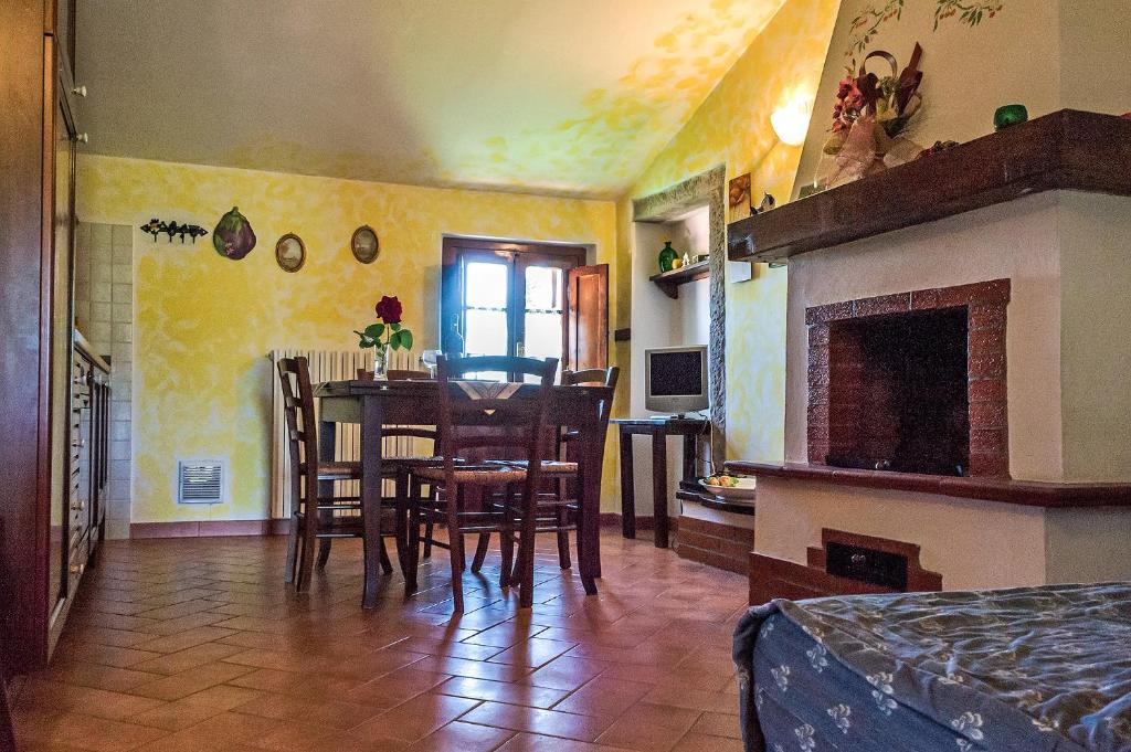a dining room with a table and chairs and a fireplace at La Casanuova in Laiatico