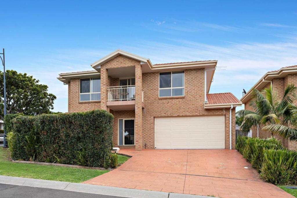 a brick house with a white garage at Sea La Vie in Shellharbour