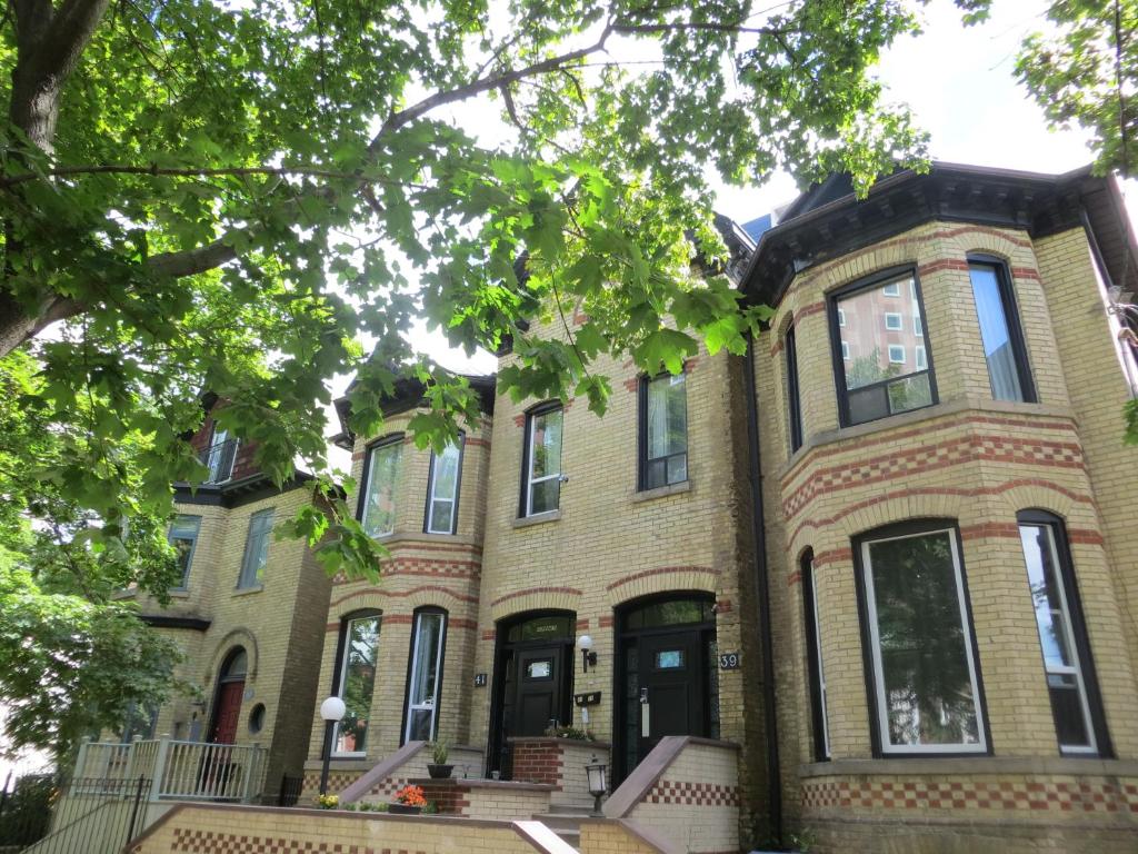 een groot bakstenen huis met zwarte deuren en ramen bij Keppner Guesthouse in Toronto