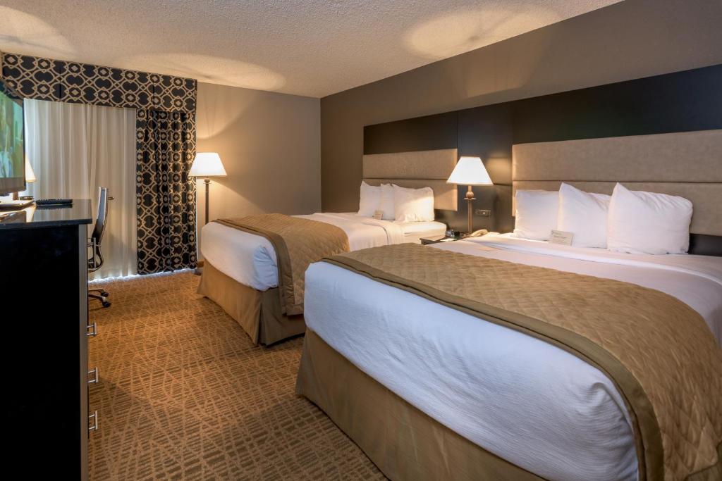 a hotel room with two beds and a television at Ramada by Wyndham Boise in Boise