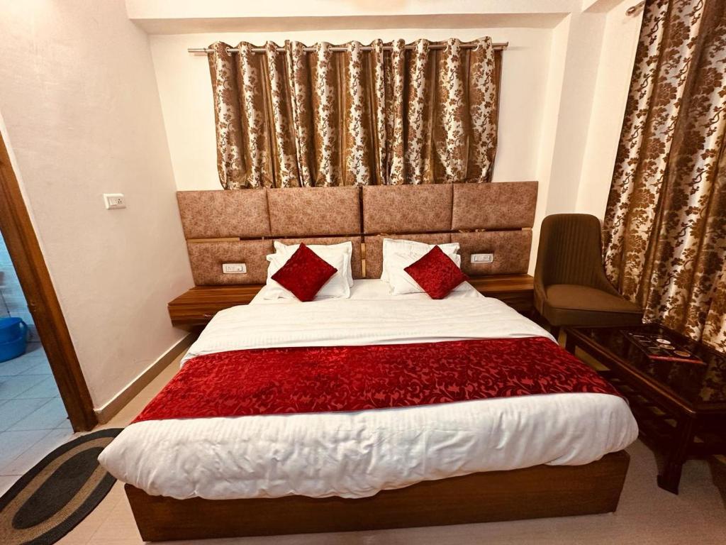 um quarto com uma cama grande e almofadas vermelhas em The Aston Hills - A Luxury Stay , Shimla em Shimla