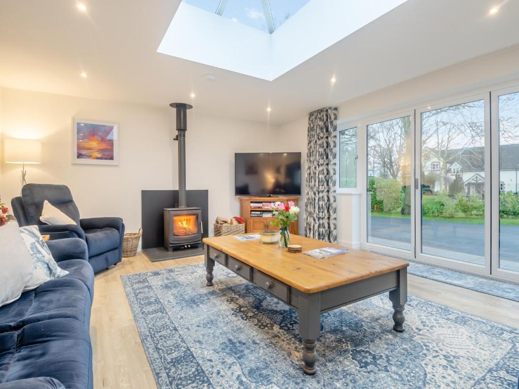 a living room with a blue couch and a table at Walcot House Stables in Diss