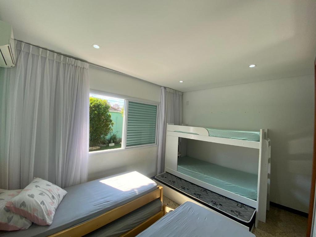 a small bedroom with a bunk bed and a window at Incrível casa em Praia Grande-SP Canto do Forte in Praia Grande