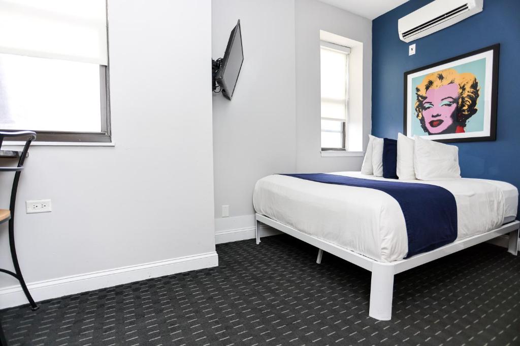 1 dormitorio con 1 cama con pared azul en Downtown Boston Studio, #36, en Boston