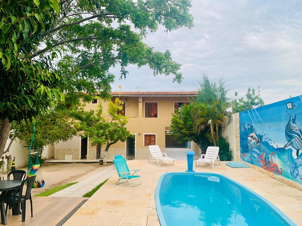 a swimming pool in front of a house at Happy Hostel e Pousada Paracuru in Paracuru