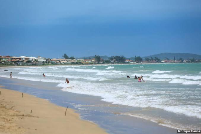 a group of people in the water at the beach at Casa PraiaRasa in Armacao dos Buzios
