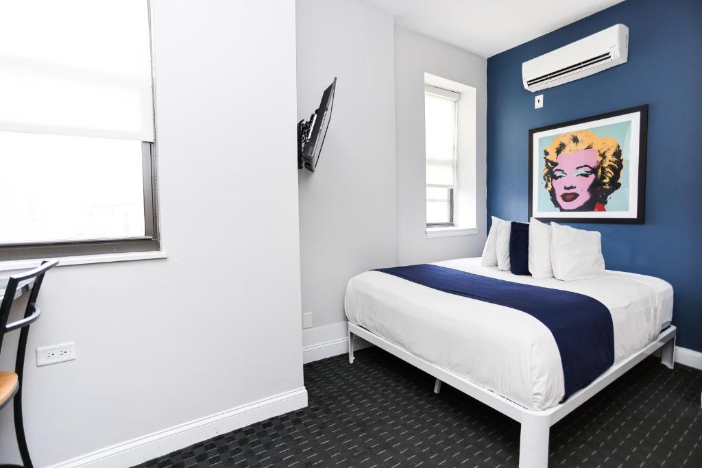 Schlafzimmer mit einem Bett mit blauer Wand in der Unterkunft Cozy Studio in Downtown Boston, #46 in Boston