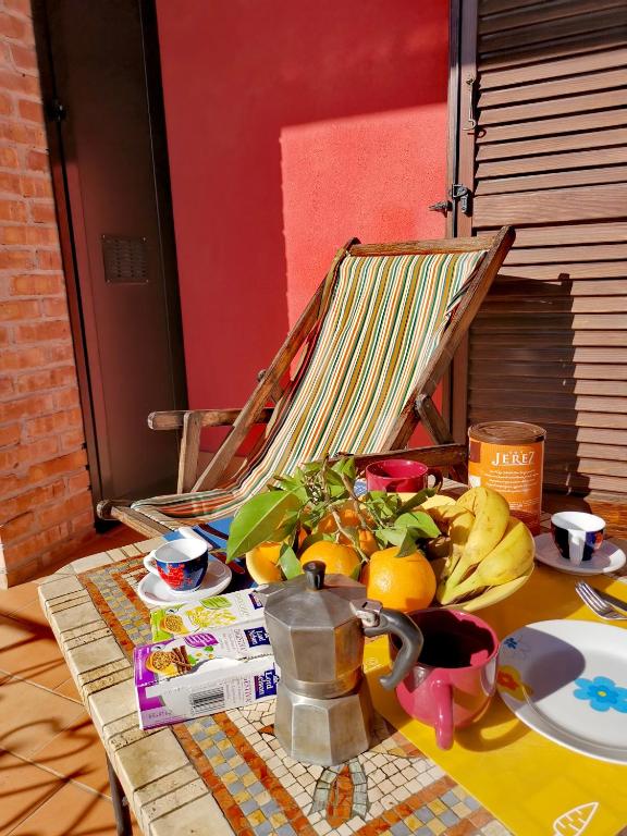 een tafel met een stapel fruit en een stoel bij LunaVerde Guesthouse in Mercato San Severino