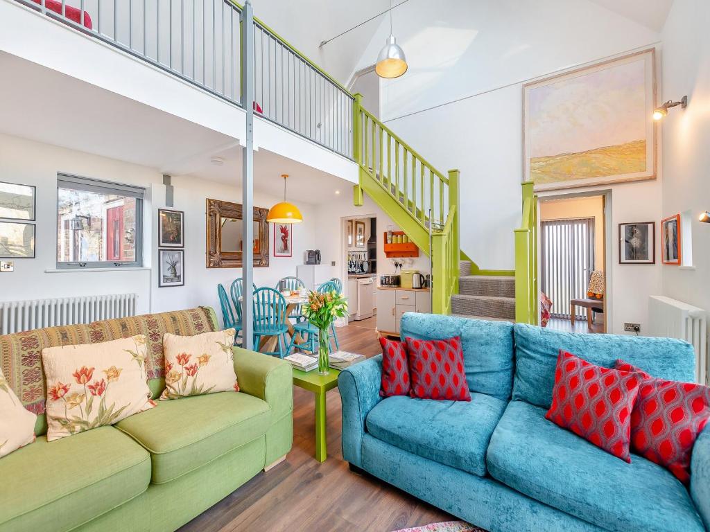 a living room with two couches and a staircase at The Sanctuary in Sleaford