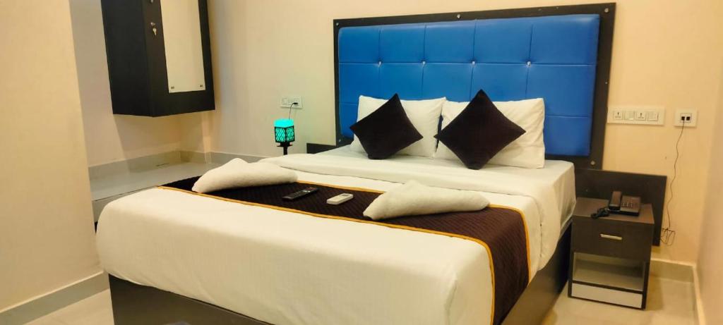 Schlafzimmer mit einem großen Bett mit blauem Kopfteil in der Unterkunft HOTELPEACOCKINN in Visakhapatnam
