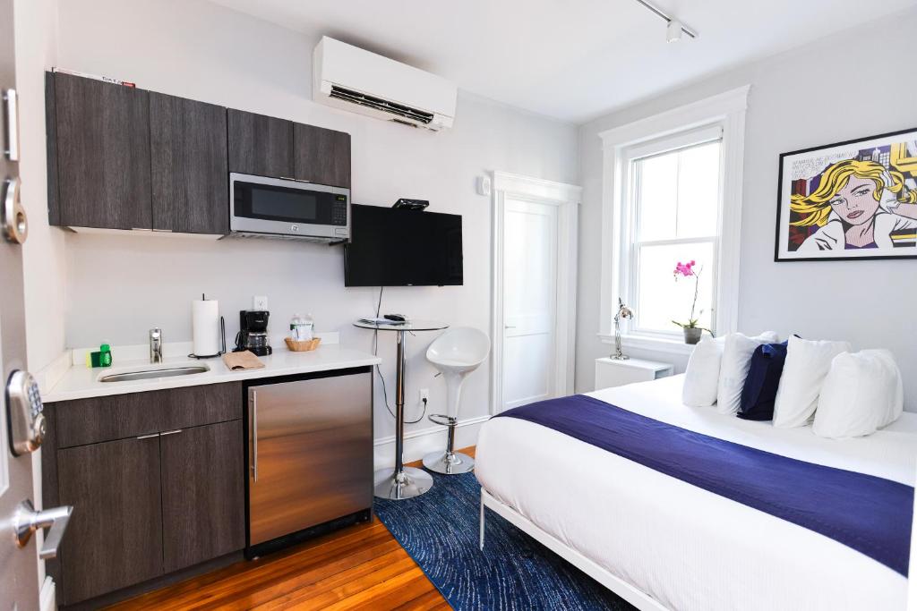 een hotelkamer met een groot bed en een bureau bij Modern Studio, quick train to Boston..#16 in Brookline