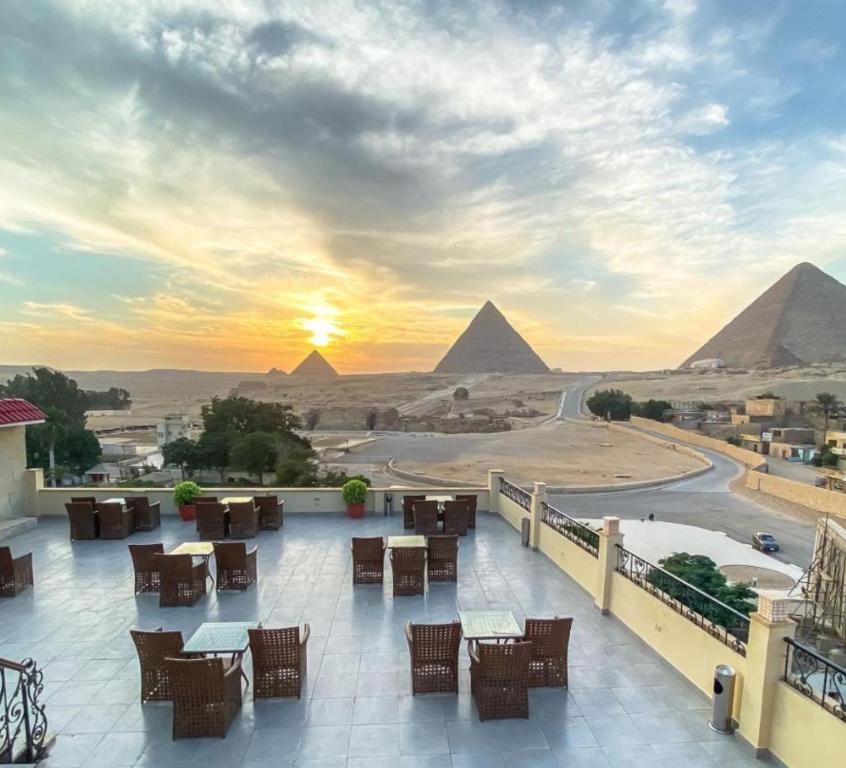 a view of the pyramids from a hotel balcony with tables and chairs at Pyramids hotel in Cairo