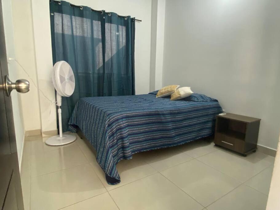 a bedroom with a bed and a fan and a window at Apartamento central in Apartadó
