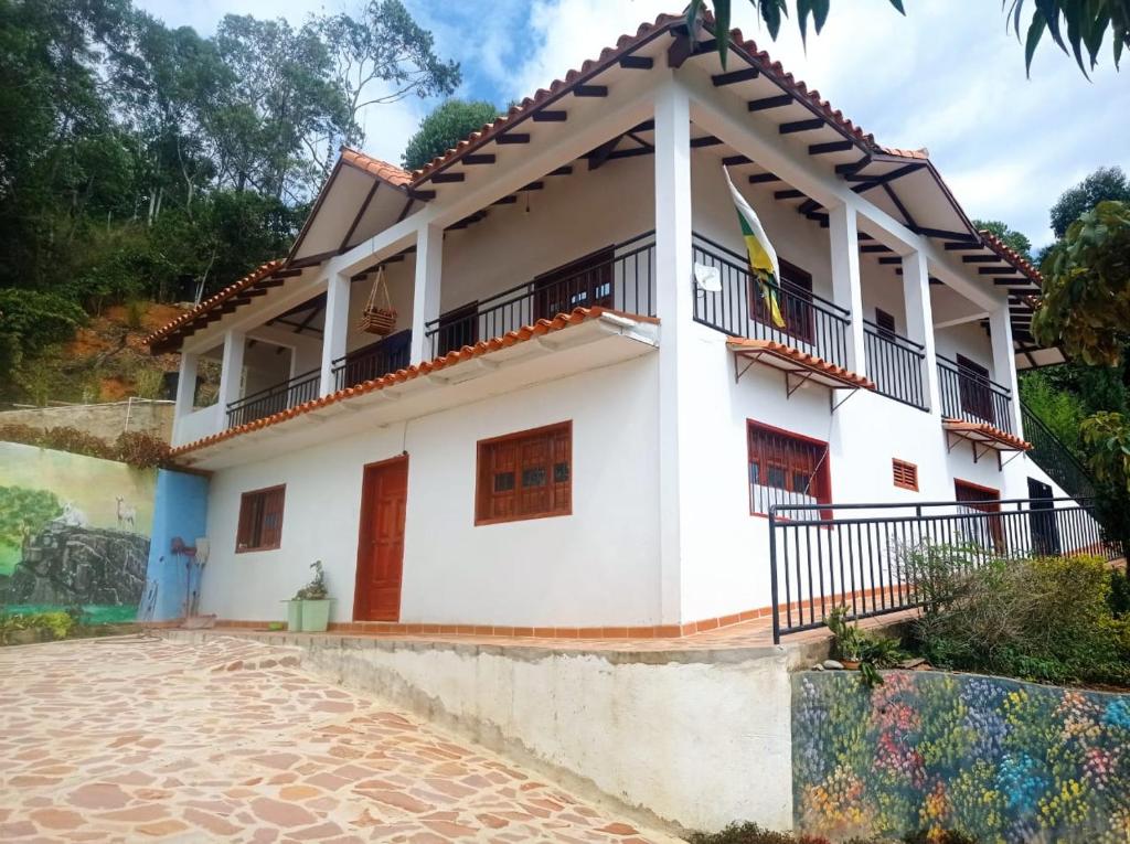 Casa blanca con bandera en el balcón en Cabaña Villa Esperanza, en Zapatoca