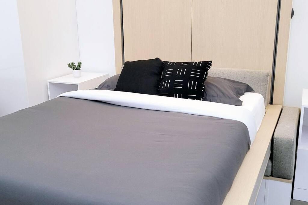 a bed with black and white pillows on it at Tremont Smart 15 - A KCM Property in Cleveland