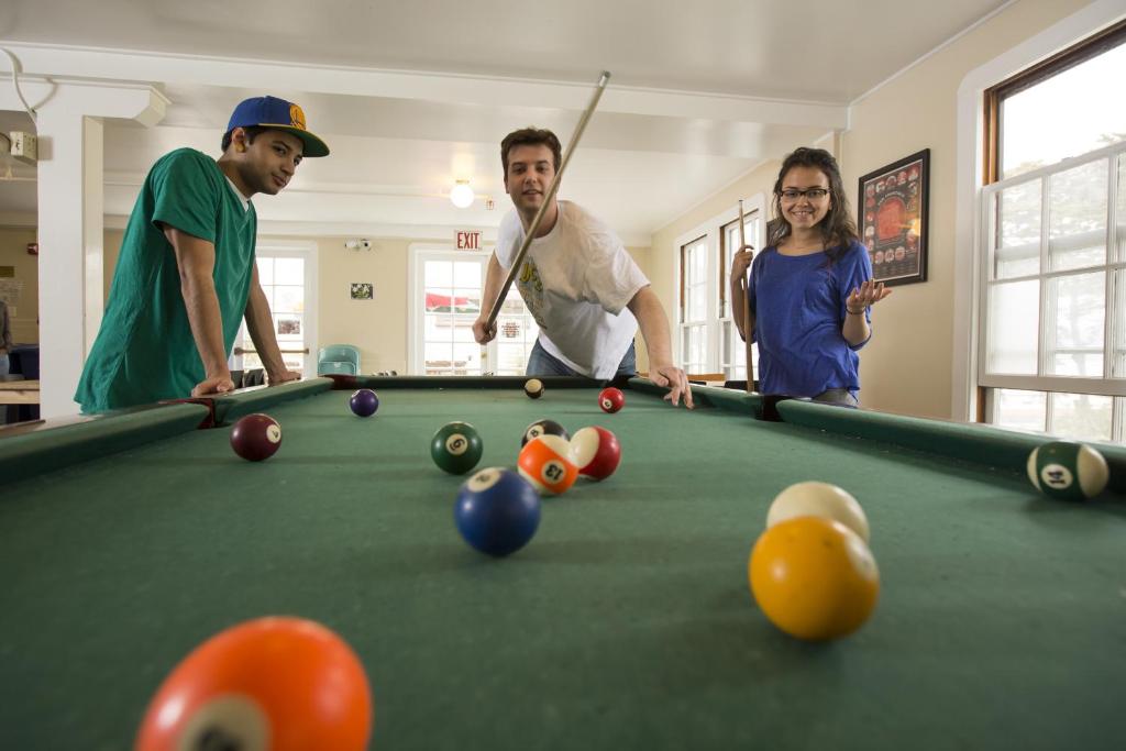 a group of three people playing a game of pool at HI San Francisco Fisherman's Wharf Hostel in San Francisco