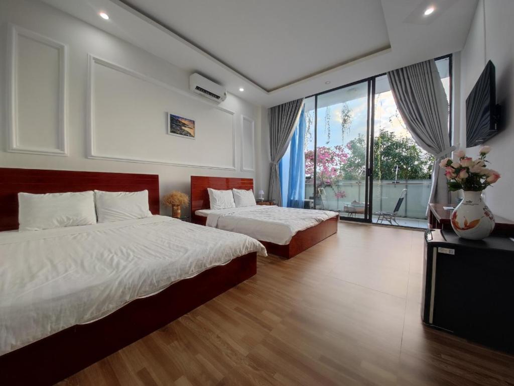 a bedroom with two beds and a flat screen tv at KHÁCH SẠN PHÚ YÊN - Khách sạn ven biển - trung tâm Tuy Hoà in Tuy Hoa