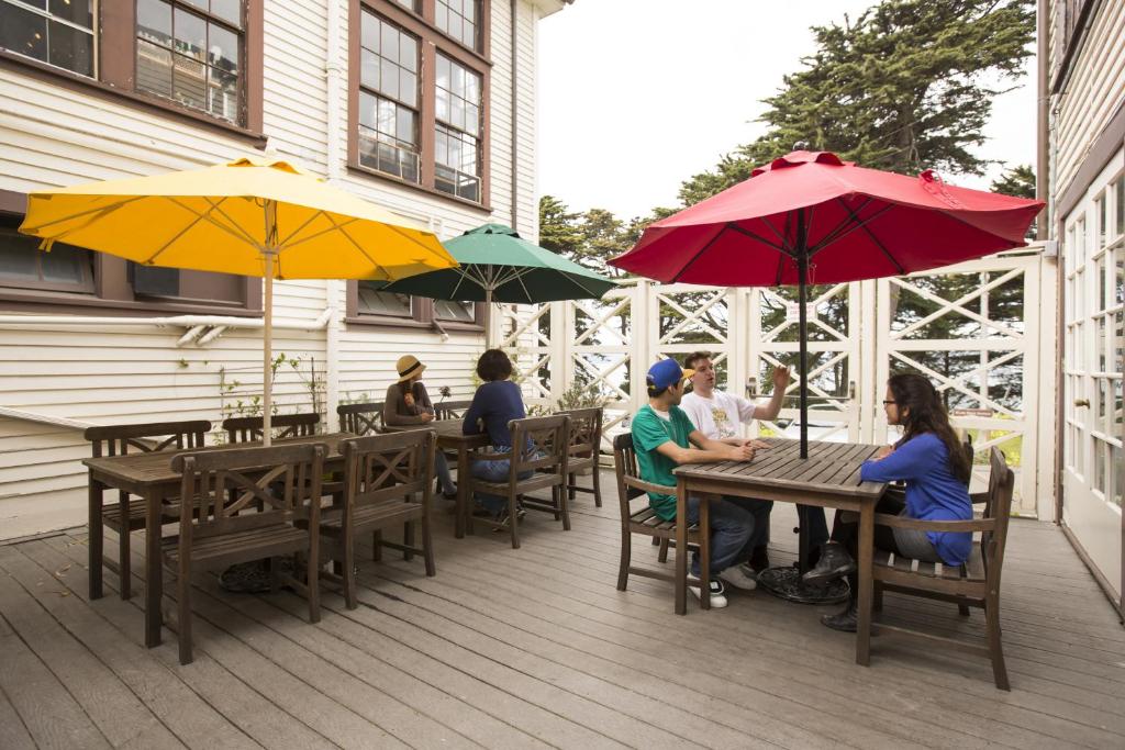 a group of people sitting at tables under umbrellas at HI San Francisco Fisherman's Wharf Hostel in San Francisco