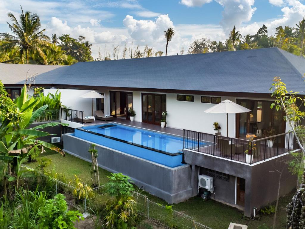 una vista exterior de una casa con piscina en The Pala Ubud by Elite Havens, en Bedahulu