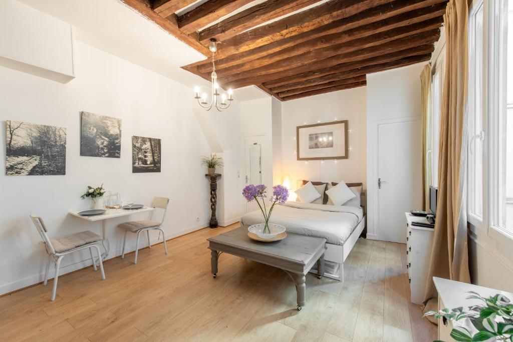 une chambre avec un lit et une table dans l'établissement Geranimus Beauregard: Heart of Paris, à Paris