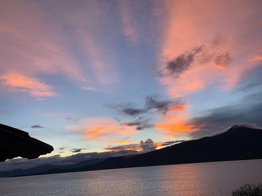 una puesta de sol sobre un cuerpo de agua con montañas en CASA ENSUEÑO, en Isla de La Pacanda