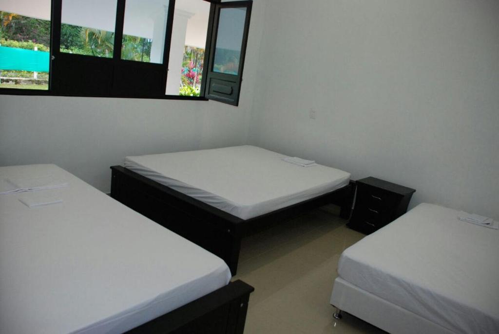 Habitación con 2 camas y 2 ventanas. en Quinta vacacional completa, en Villavicencio
