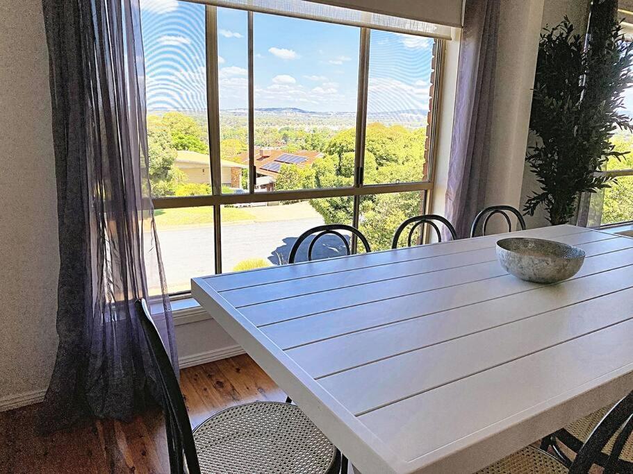 a table with a bowl on it in front of a window at Glens Haven with Lakeviews and Outdoor Firepit in Wagga Wagga