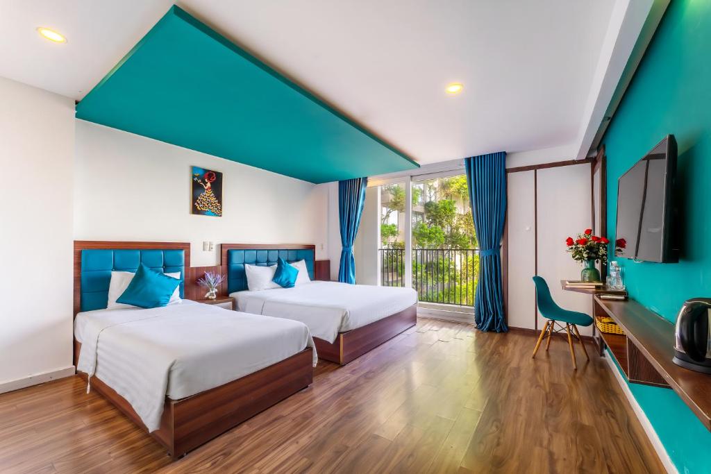 Habitación de hotel con 2 camas y TV en Rich Hotel, en Da Nang