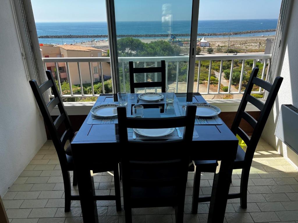 - une table à manger avec des chaises et une vue sur la plage dans l&#39;établissement Appartement Sète, 1 pièce, 4 personnes - FR-1-338-532, à Sète