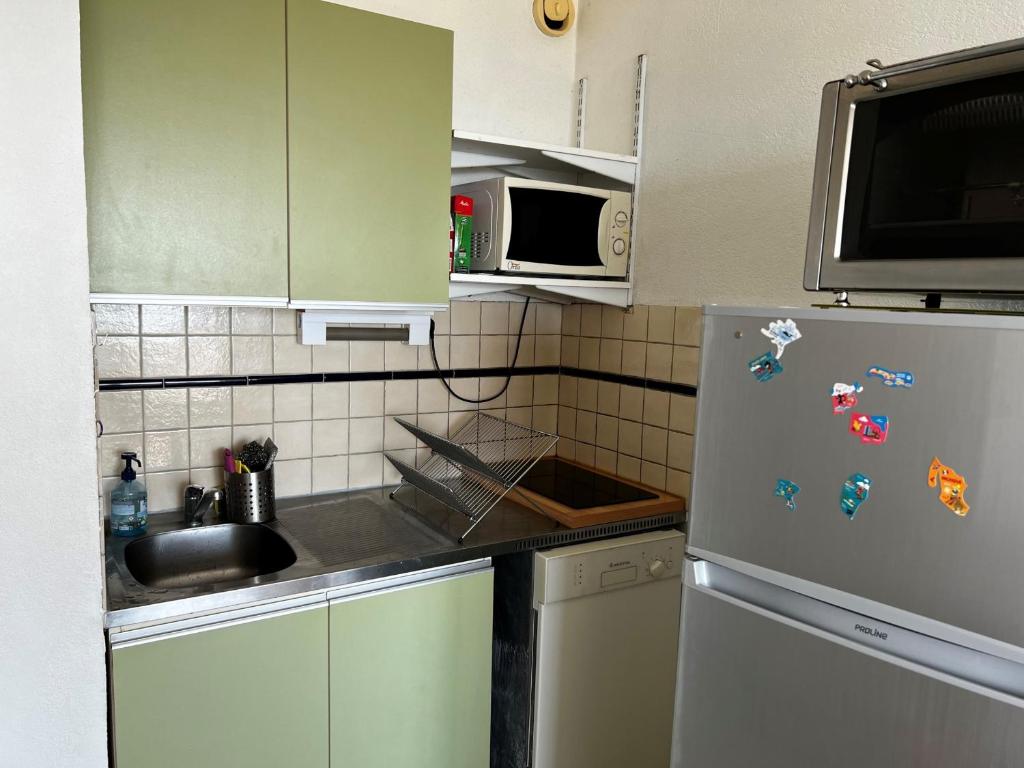 Il comprend une cuisine équipée d&#39;un réfrigérateur avec des aimants. dans l&#39;établissement Appartement Sète, 1 pièce, 4 personnes - FR-1-338-532, à Sète